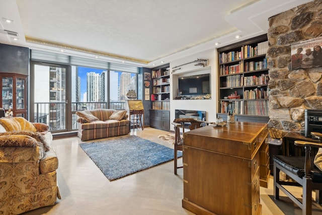 office space with built in shelves, a fireplace, and light parquet flooring