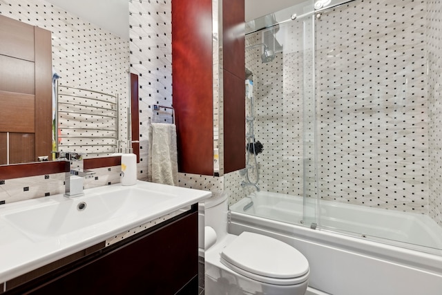 full bathroom with enclosed tub / shower combo, vanity, and toilet