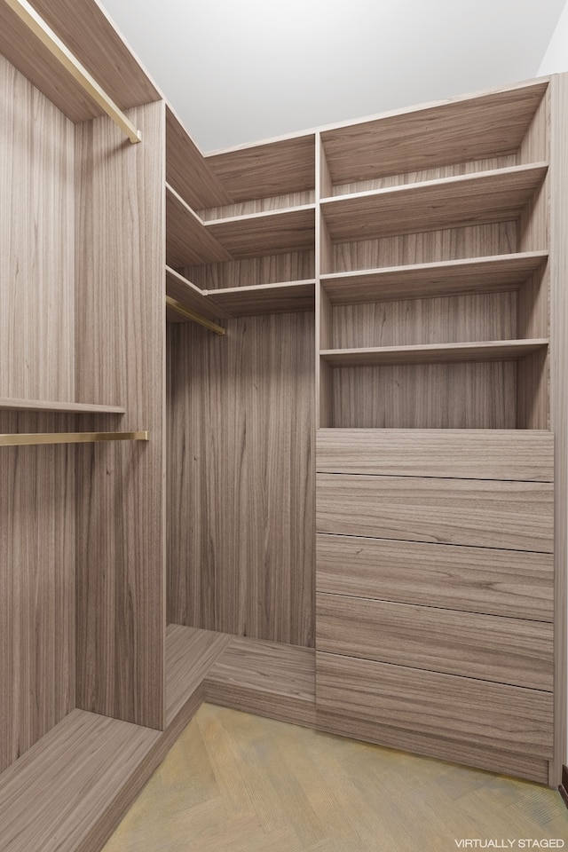 walk in closet with parquet flooring