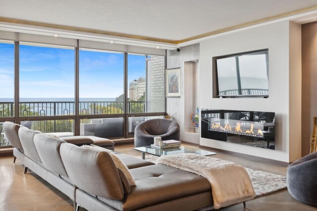 living room with light hardwood / wood-style flooring, floor to ceiling windows, a water view, and a wealth of natural light