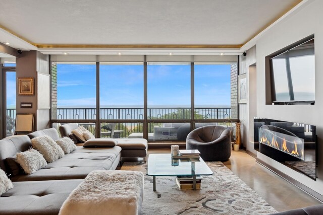 living room with a wall of windows, a water view, and plenty of natural light