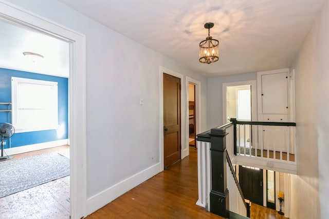 hall featuring a notable chandelier and hardwood / wood-style flooring