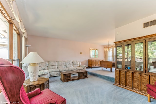 carpeted living room featuring a chandelier