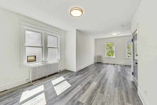 spare room featuring radiator heating unit and hardwood / wood-style flooring