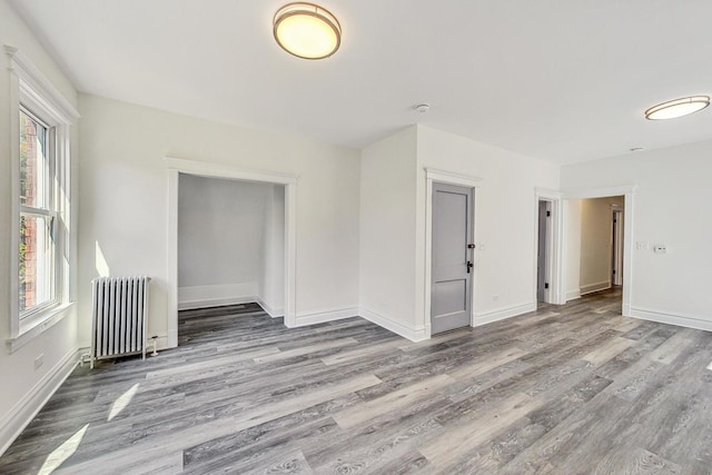 empty room with light hardwood / wood-style flooring and radiator