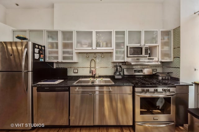 kitchen with stainless steel appliances, dark hardwood / wood-style floors, sink, and tasteful backsplash