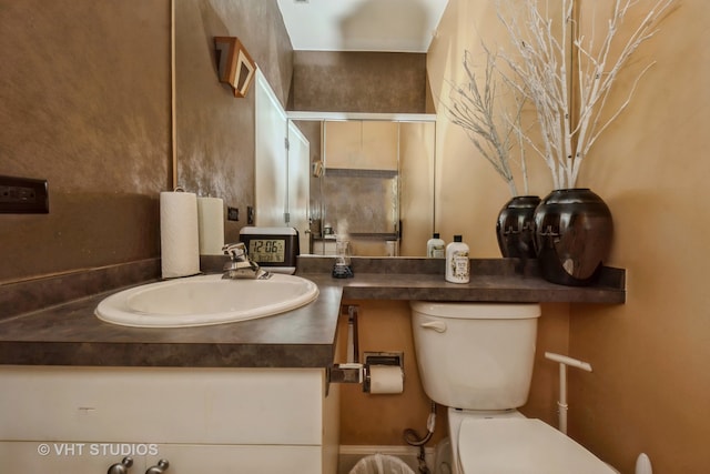 bathroom featuring walk in shower, vanity, and toilet