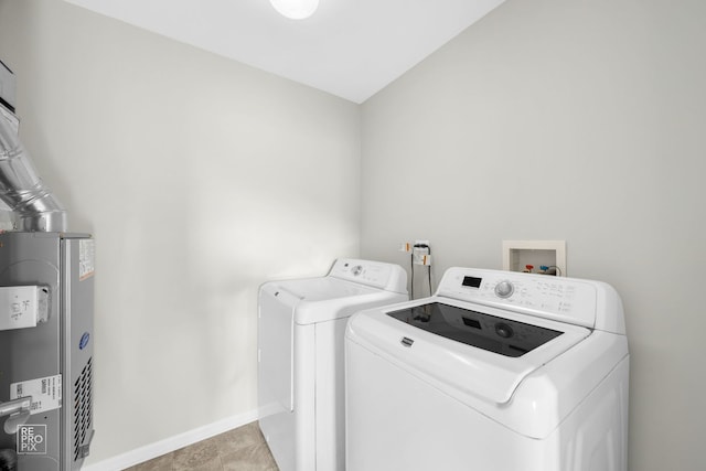 clothes washing area featuring washer and dryer and water heater