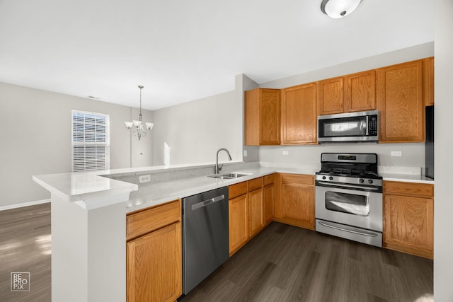 kitchen featuring pendant lighting, sink, kitchen peninsula, and stainless steel appliances