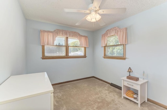 interior space featuring ceiling fan, light colored carpet, and a textured ceiling