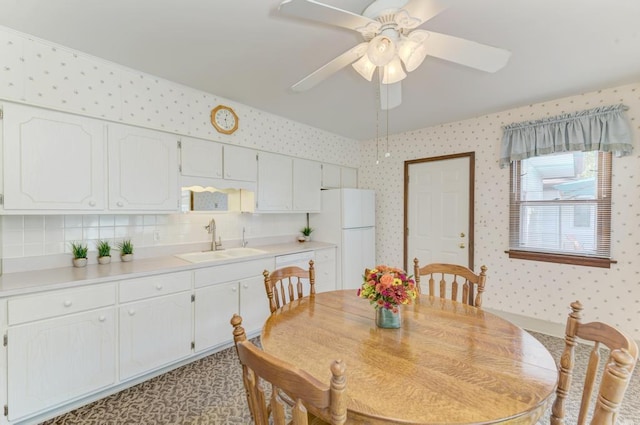 dining space featuring ceiling fan, vaulted ceiling, and sink