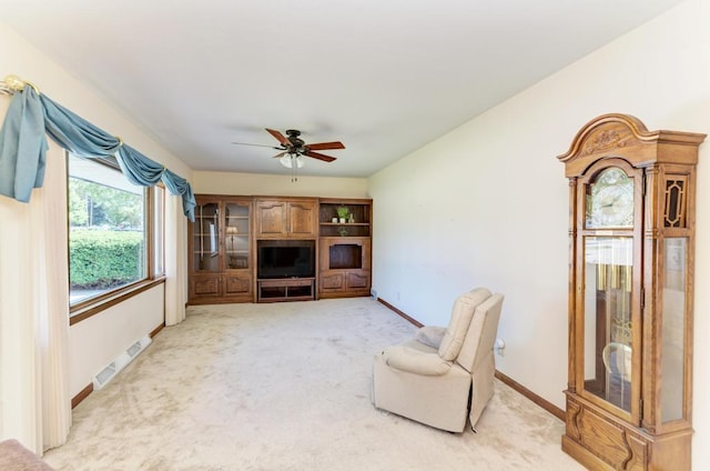 unfurnished living room featuring ceiling fan and light colored carpet