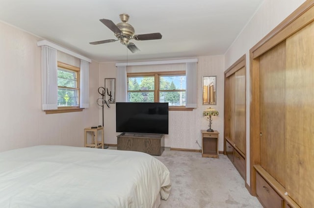 carpeted bedroom with ceiling fan and multiple closets