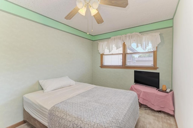 carpeted bedroom with ceiling fan and a textured ceiling