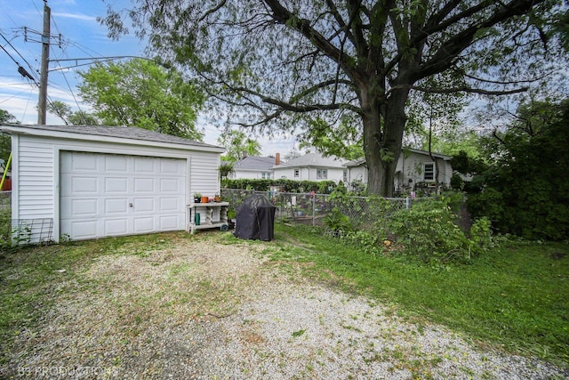 detached garage with driveway and fence