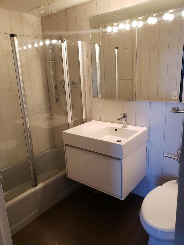 full bathroom featuring tile walls, vanity, and toilet