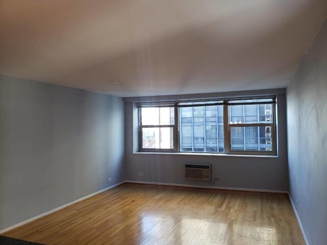 empty room featuring light hardwood / wood-style floors and a wall mounted air conditioner