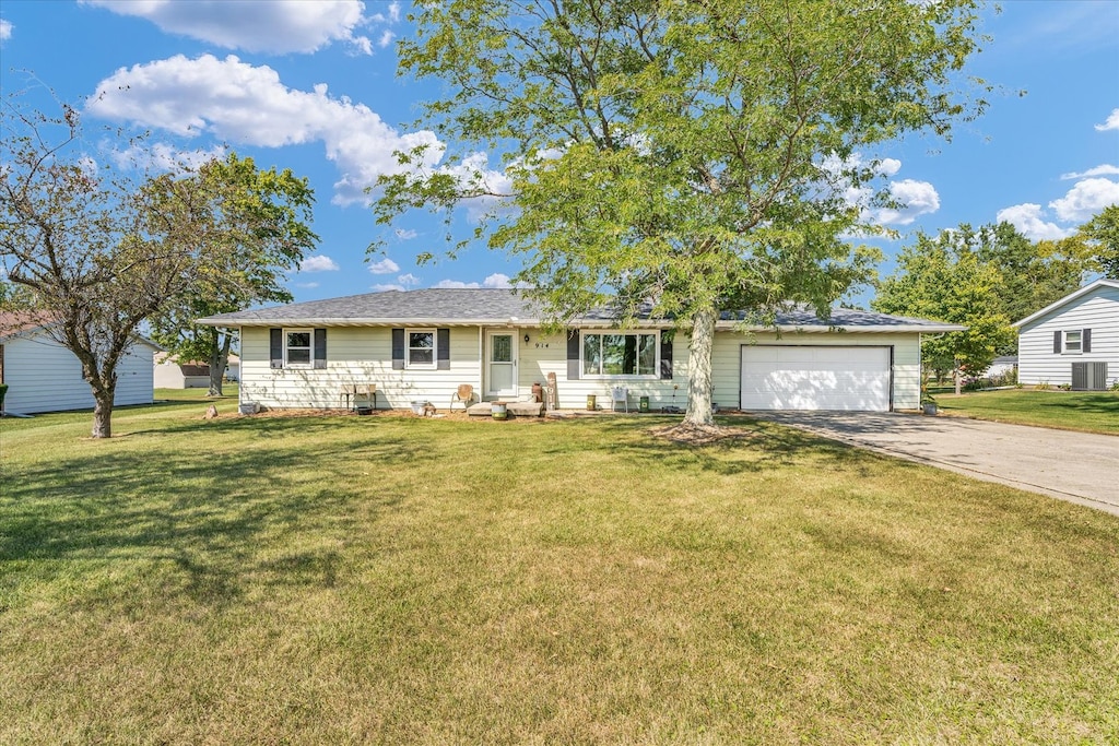 single story home featuring a garage, a front lawn, and central AC