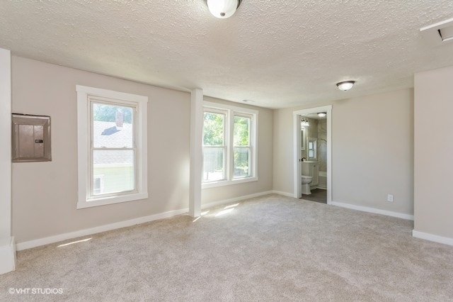 carpeted empty room with electric panel and a textured ceiling