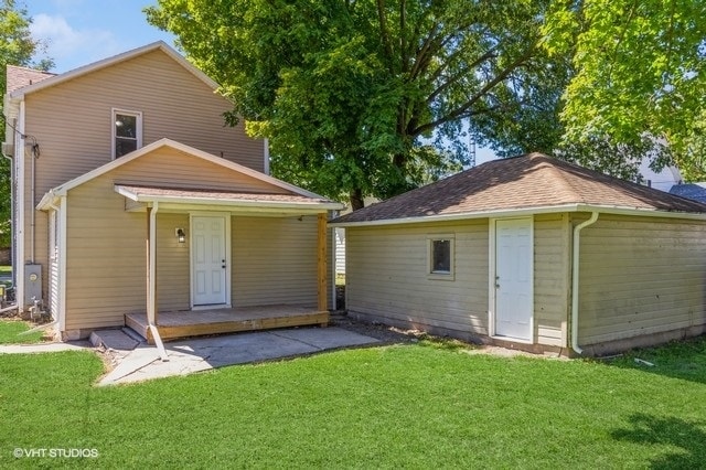 rear view of property featuring a lawn