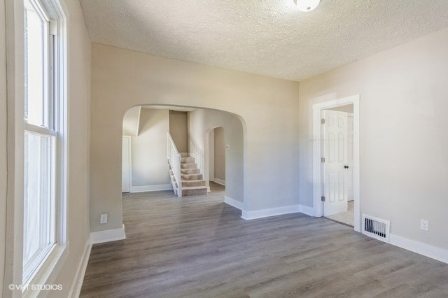 empty room featuring a textured ceiling and hardwood / wood-style floors