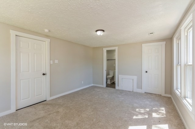 carpeted spare room with a textured ceiling