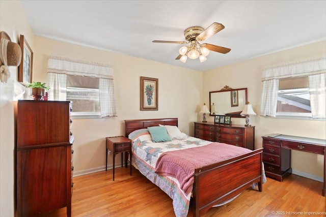 bedroom with ceiling fan, light hardwood / wood-style flooring, and multiple windows