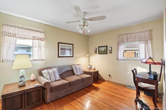 living room with light hardwood / wood-style floors and ceiling fan