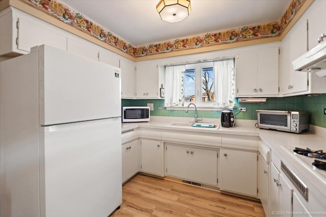 kitchen featuring sink, white appliances, and white cabinets