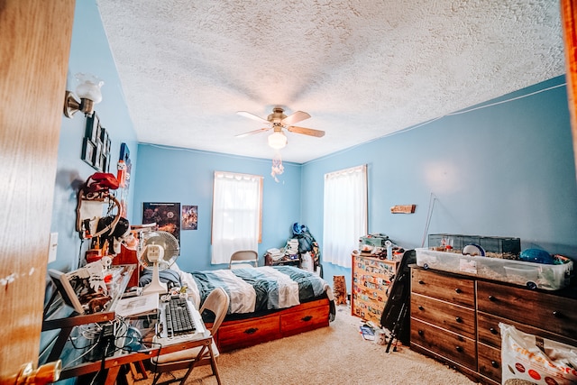 bedroom featuring ceiling fan, carpet floors, and a textured ceiling