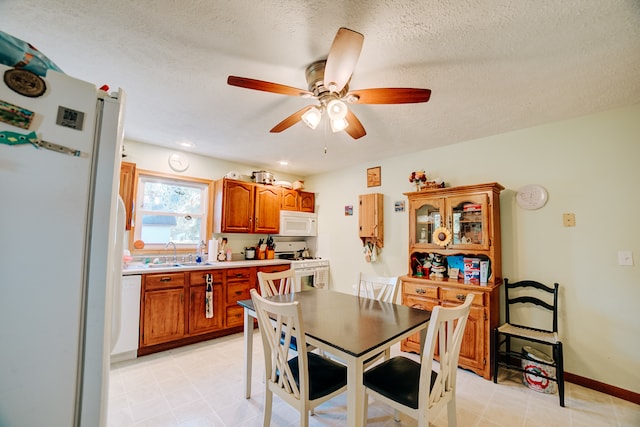 dining room featuring ceiling fan, a textured ceiling, and sink