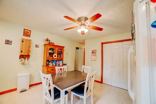 dining area with ceiling fan and a textured ceiling