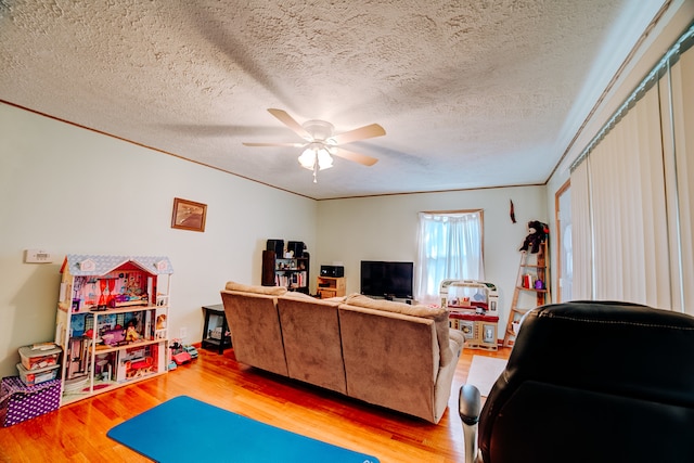 interior space with ceiling fan, hardwood / wood-style flooring, crown molding, and a textured ceiling