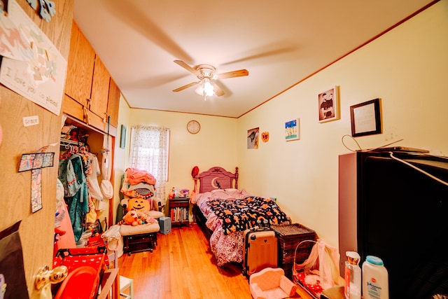 bedroom featuring crown molding, ceiling fan, light hardwood / wood-style flooring, and a closet