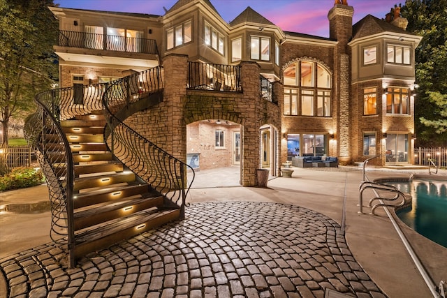 exterior space featuring a fenced in pool, a balcony, and a patio area