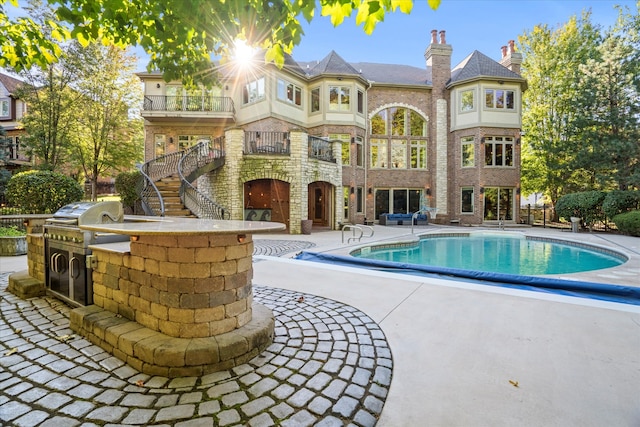 view of swimming pool with area for grilling, a grill, and a patio area