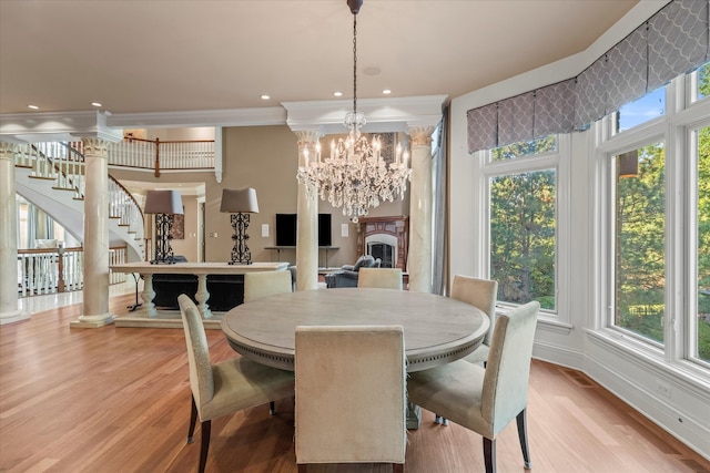 dining room featuring light wood-type flooring, a notable chandelier, and crown molding