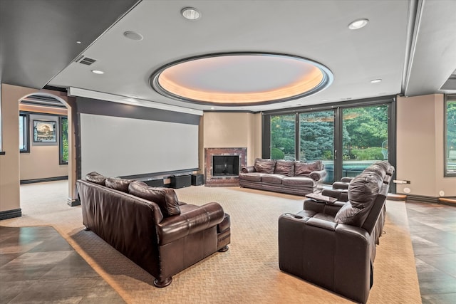 cinema featuring a tray ceiling and a large fireplace