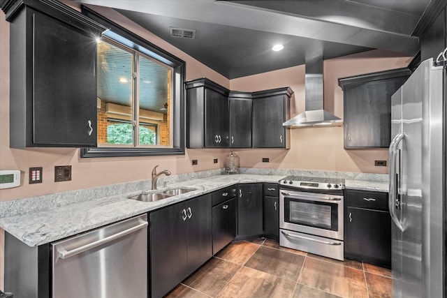 kitchen featuring stainless steel appliances, wall chimney exhaust hood, sink, and light stone counters