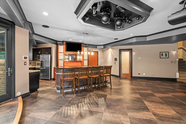 bar with decorative light fixtures and stainless steel fridge