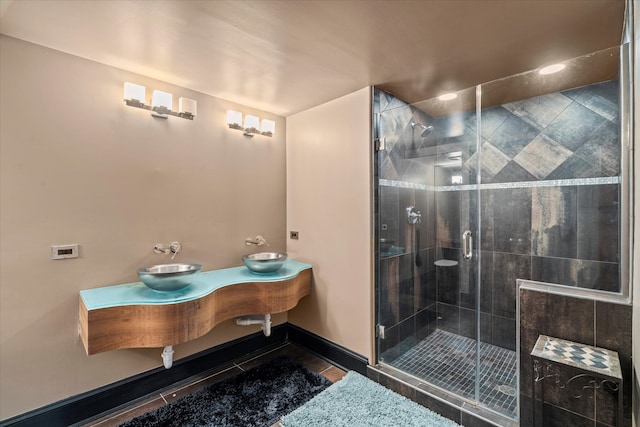 bathroom featuring a shower with shower door, vanity, and tile patterned flooring