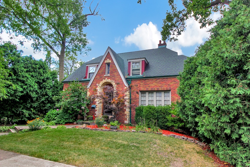 english style home featuring a front yard