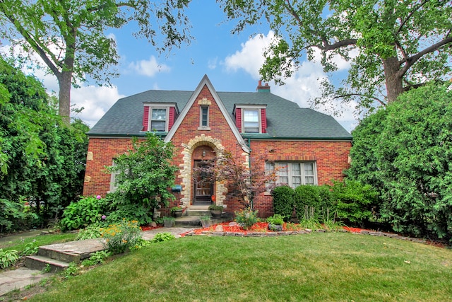 tudor home with a front lawn