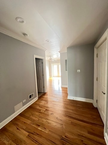 spare room with ornamental molding and dark wood-type flooring