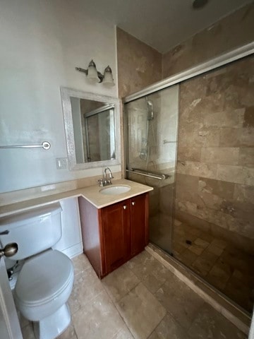 bathroom with walk in shower, vanity, and toilet