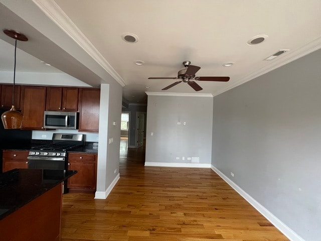 kitchen with ornamental molding, light hardwood / wood-style floors, ceiling fan, and appliances with stainless steel finishes