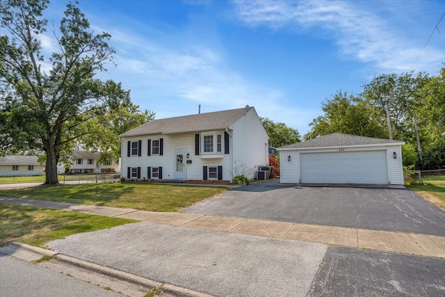 raised ranch with cooling unit, a garage, an outdoor structure, and a front lawn