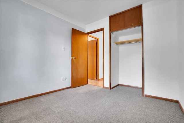 unfurnished bedroom with light carpet and a closet