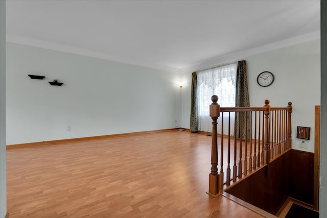 unfurnished room featuring ornamental molding and light hardwood / wood-style flooring