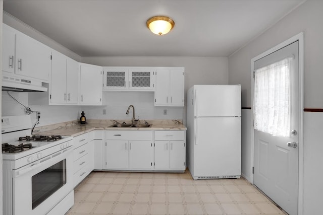 kitchen with white appliances, white cabinetry, and sink